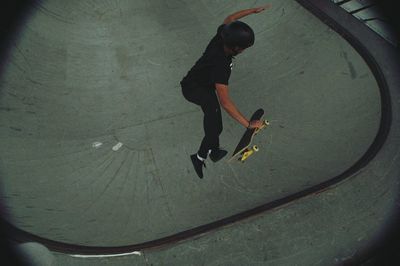 High angle view of person with surfboard jumping at park