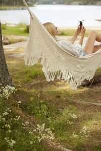 Woman using phone on hammock