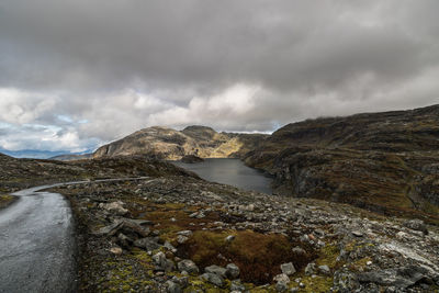 Scenic view of mountains and lake against cloudy sky