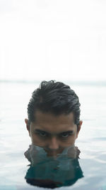 Close-up portrait of young woman against sea