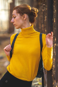 Young woman looking down while standing outdoors