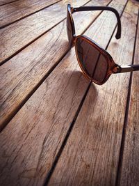 High angle view of sunglasses on wooden floor