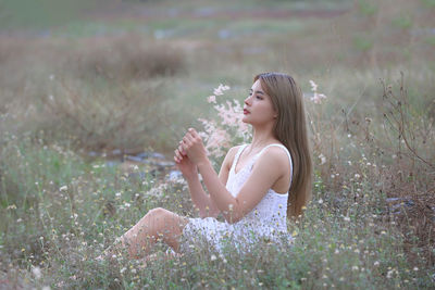 Beautiful woman sitting on field