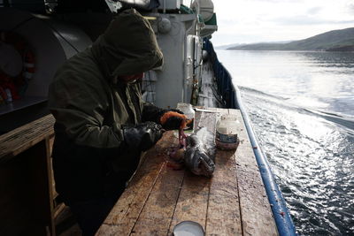 Side view of man working on boat