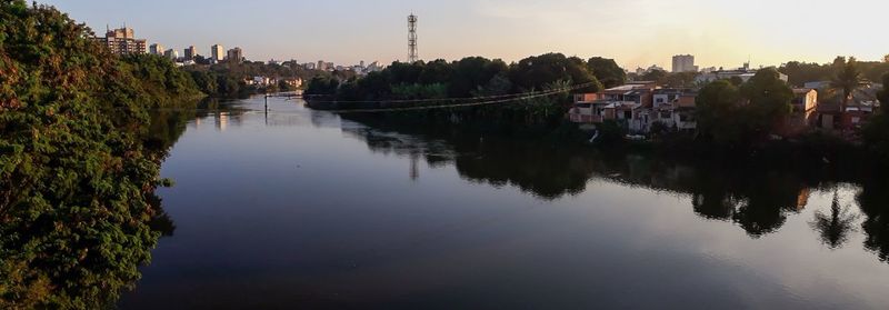 Scenic view of river by buildings against sky