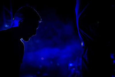 Close-up of silhouette man standing at night