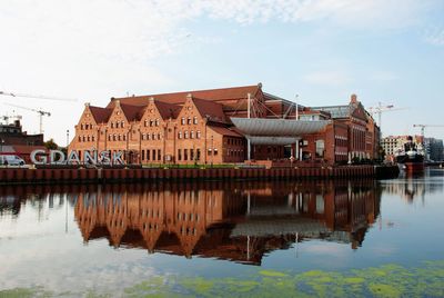 Reflection of buildings on river against sky