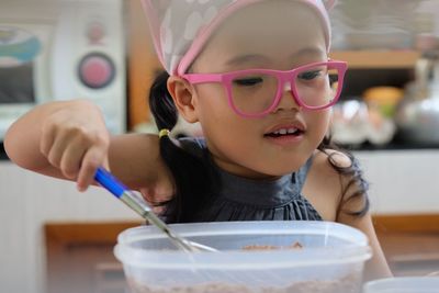 Close-up of cute girl preparing food on table