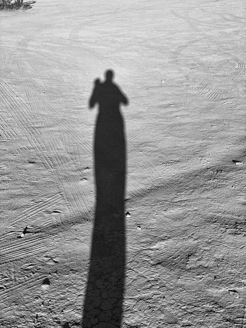 SHADOW OF PERSON ON SAND ON BEACH