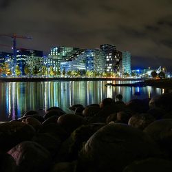 View of skyscrapers in front of sea at night