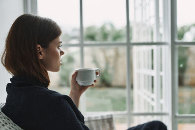 Mid adult woman holding coffee cup