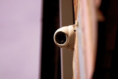 Low angle view of security camera on wall during sunset
