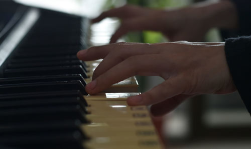 Close up of man hands playing piano