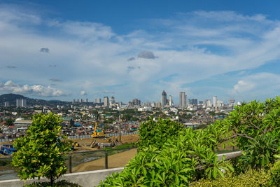 Buildings in city against cloudy sky