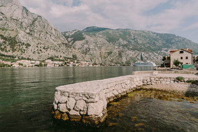 Scenic view of lake by mountains against sky