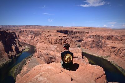 Rear view of man sitting on rock at grand canyon national park