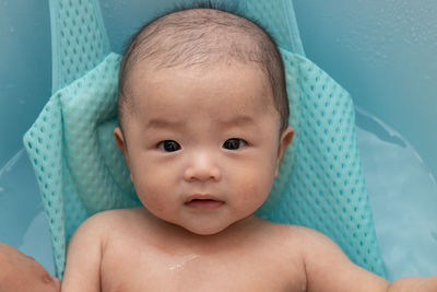 Cute baby girl lying in container