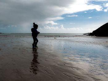 Man standing on beach against sky