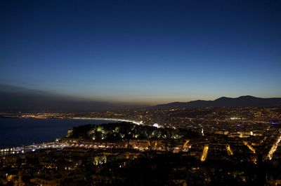 Illuminated cityscape against sky at night