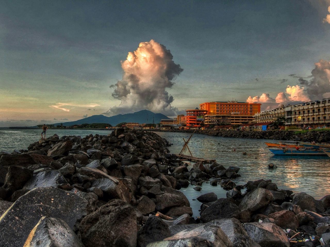 water, sky, sea, cloud - sky, built structure, rock - object, architecture, cloudy, building exterior, beach, shore, sunset, scenics, nature, beauty in nature, cloud, pier, weather, stone - object, horizon over water