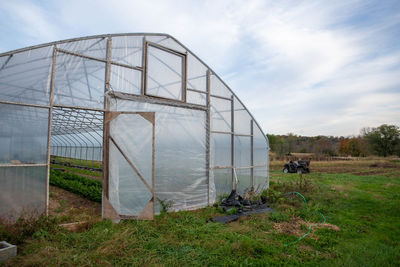 Vegetable garden greenhouse in rural farm scene with off road vehicle