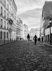 People walking on footpath in montmartre street in paris 