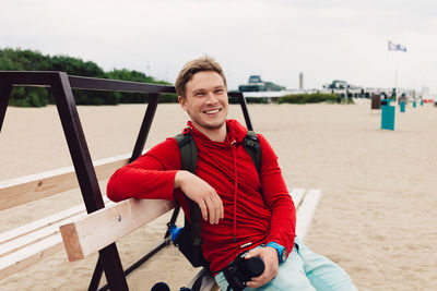 Portrait of smiling man sitting on beach