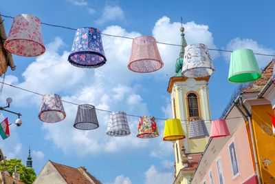 Low angle view of lanterns hanging by building against sky