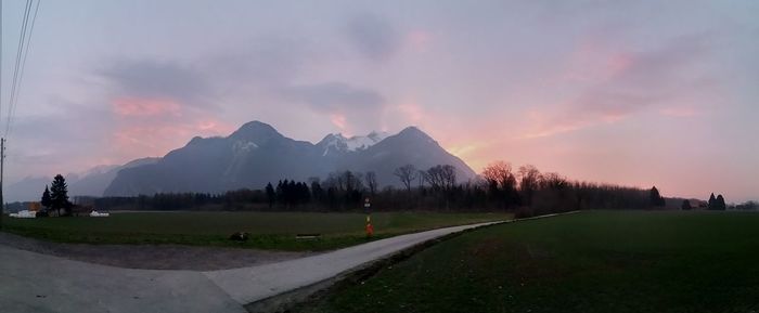 Scenic view of grassy field against cloudy sky