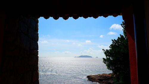 Scenic view of sea seen through building
