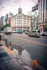 Cars on city street against sky