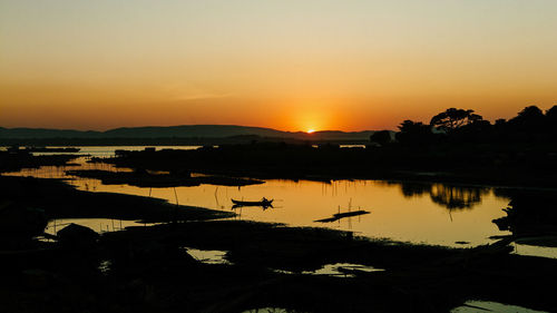 Scenic view of lake against orange sky