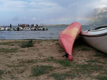 Boats moored on beach against sky