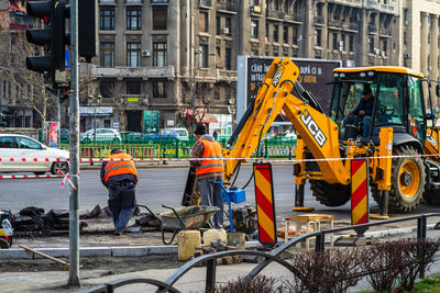 People working at construction site in city