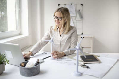 Woman using smart phone while sitting on table