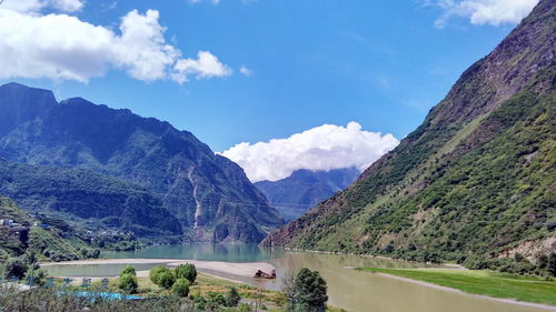 Scenic view of river and mountains against sky