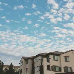 Buildings in city against cloudy sky