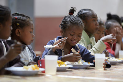 Madagascar, fianarantsoa, children eating their school lunch