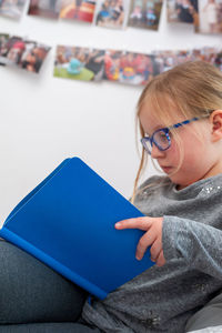 School age girl sitting in her bedroom and doing school homework.