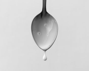 Low angle view of spoon against blue background