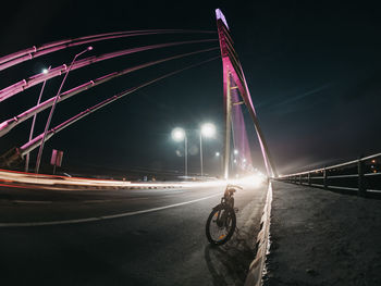 Light trails on road against sky at night