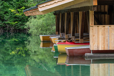 Line of multi coloured rowboats in a wooden boathouse