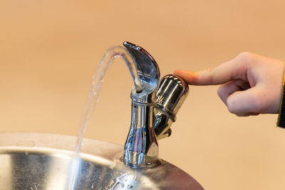 Cropped hand of child pressing tap in bathroom