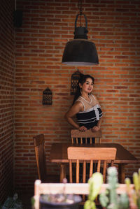 Woman standing against brick wall