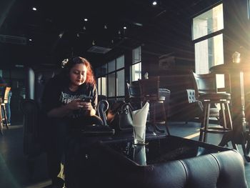 Young woman using laptop while sitting on table