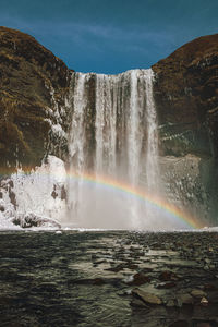 Scenic view of rainbow over sea against sky