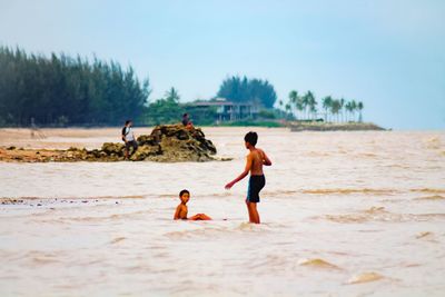 People on beach against sky