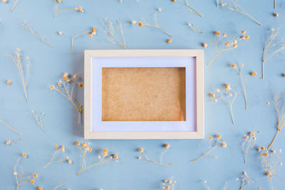 Directly above shot of picture frame with flowers on table