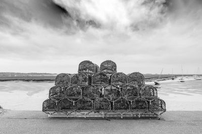 Crab pots on beach against sky