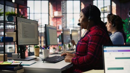 Side view of young woman using laptop at office